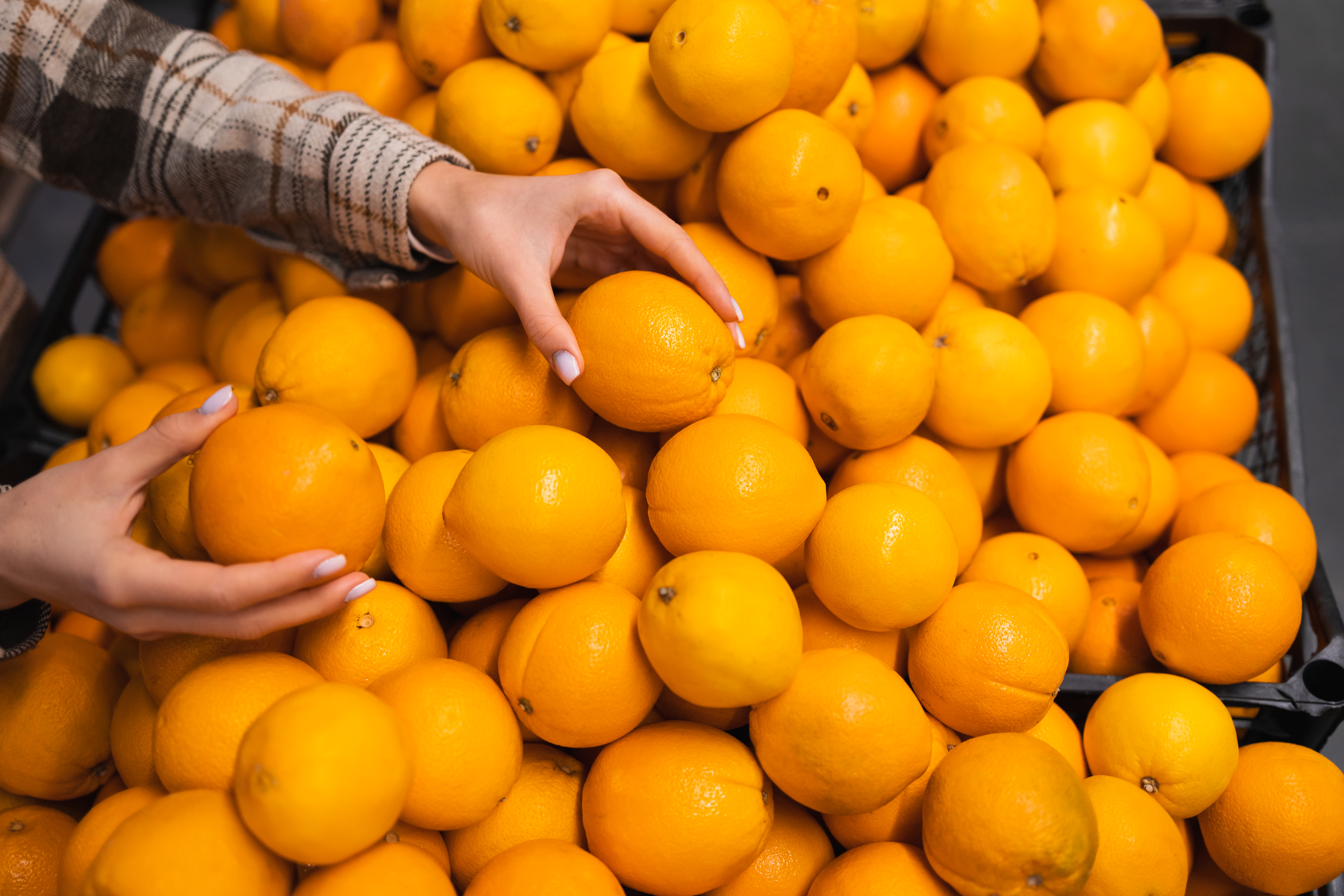 close-up-of-woman-s-hands-taking-oranges-from-supe-2023-11-27-05-04-55-utc.jpg